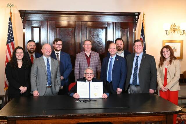 131214613_web1_dcf573e1-5ce5-0790-8e6d-41239a86d812
Pictured are County Commissioners Association of Ohio Policy staffers Kyle Petty, Rachel Reedy, and James Kennedy attended the House Bill 497 signing ceremony with sponsors Brian Stewart and Roy Klopfenstein, their legislative aides, Governor Mike DeWine, and Lt. Governor Jon Husted. Photo courtesy the County Commissioners Association of Ohio.