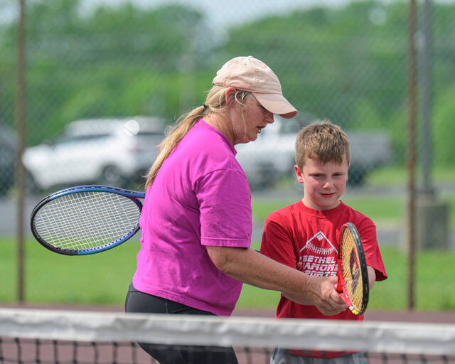 131563550_web1_B-T-Tennis-Camp Bethel-Tate head tennis coach Lori Lenhart works with Henry Wyatt during the Bethel Area Tennis Association Community Tennis Programs Swing, Hit and Ace camp May 15, 2025, behind Bethel-Tate Middle School. Photo by Sun Sports Reporter Jake Dowling