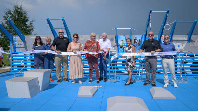 131616623_web1_Fitness-Court-5 Local officials pose for a ribbon-cutting ceremony of the new Fitness Court and mural June 27, 2025, at Community Park in Milford. Photo by Sun Sports Reporter Jake Dowling