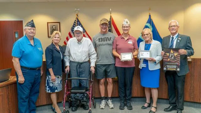 Commissioner David Painter, on right, holds the 2026 POW/MIA Poster, while Board President Bonnie Batchler, second from right, and DAV Chapter #63 Treasurer Susan Ward, third from right, display the Korean War First Day Covers presented to Commissioners. From the left are Chapter #121 Adjutant Plahovinsak, followed by Commissioner Clair Corcoran; KWVA Chapter #121 member Ray Hutchinson and Peter Ward, DAV Chapter #63 member. Photo courtesy Clermont County Multimedia Specialist David Scheibenzuber.